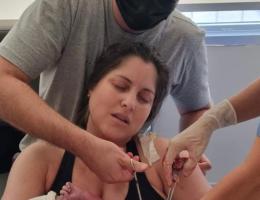 Papai Guilherme cortando o cordão umbilical da bem-nascida Esther.