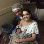 Joaquim no colo de Ísis e Bernardo na penumbra