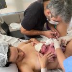 Papai Saulo cortando o cordão umbilical  da Letícia