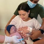 Papai Guilherme cortando o cordão umbilical do Gabriel .