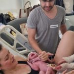 Papai Fabrício cortando o cordão umbilical da Maria Valentina.