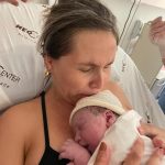 A mamãe Ludimila emocionada com o Luiz Henrique nos braços.