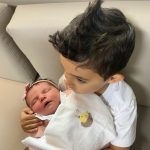 Bianca aproveitando o colo do irmãozinho Hugo.