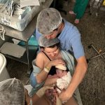 O papai Daniel cortando o cordão umbilical do Davi..